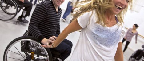ambulatory man and woman in a wheelchair dancing