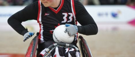 wheelchair rugby player with the ball in his lap